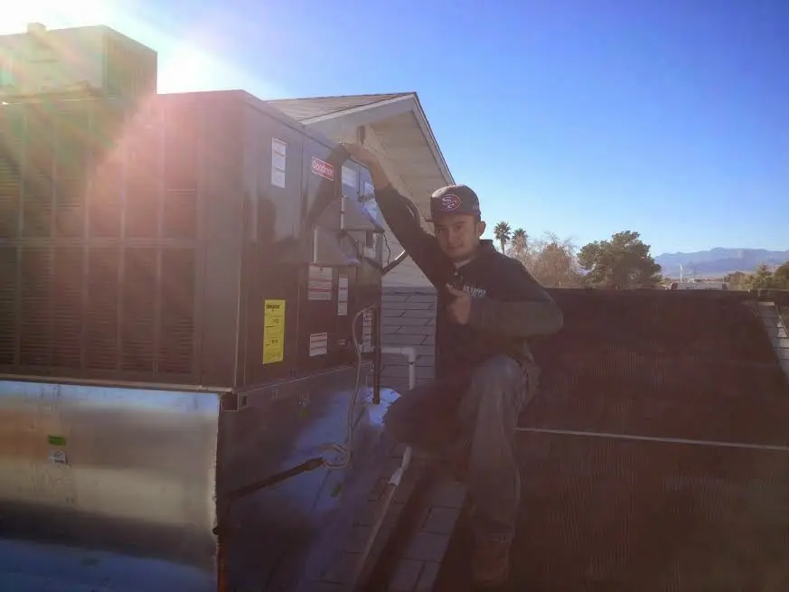 HVAC technician performing AC Tune-Up on a rooftop unit in South St. Paul
